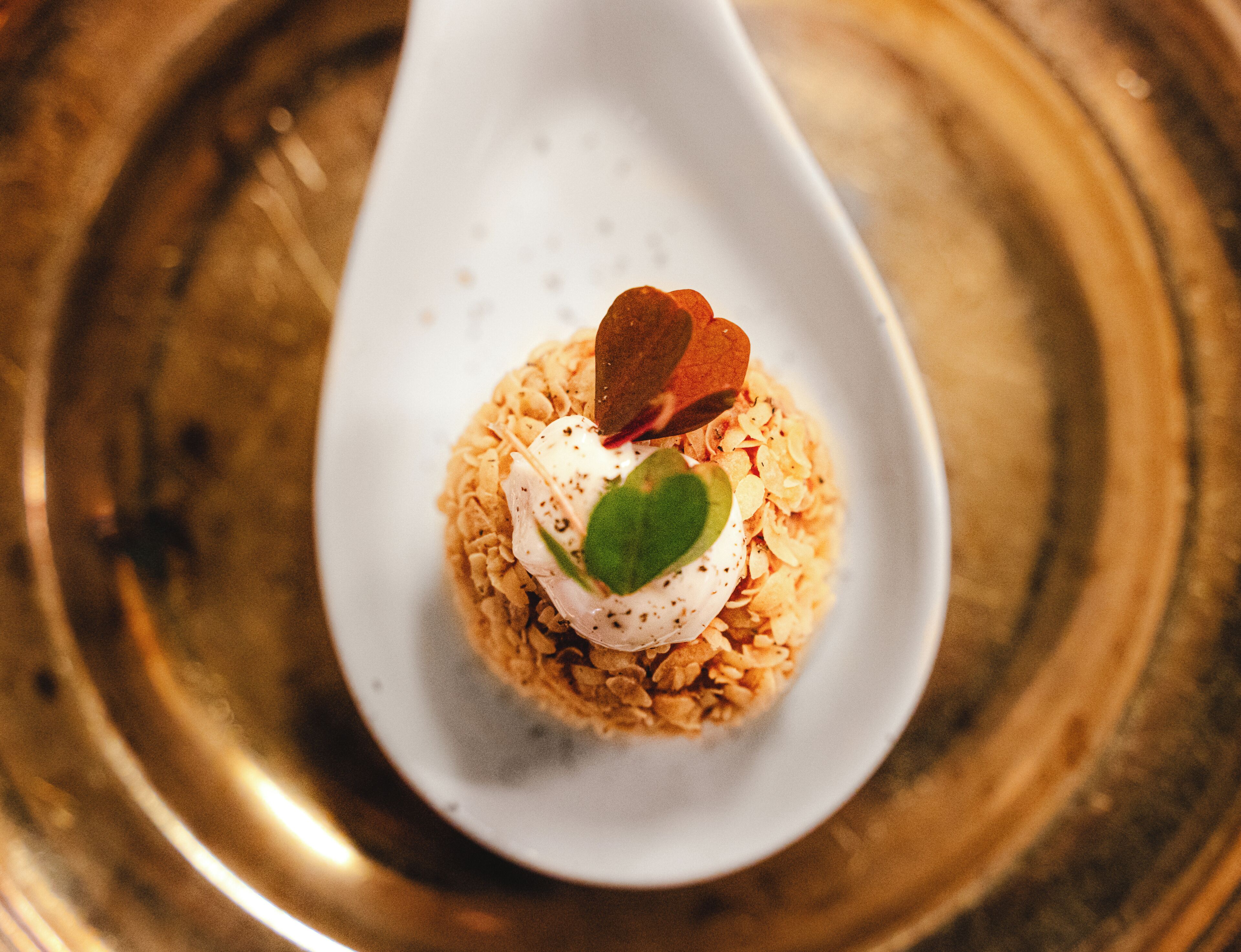 A white spoon with a dessert on it.
