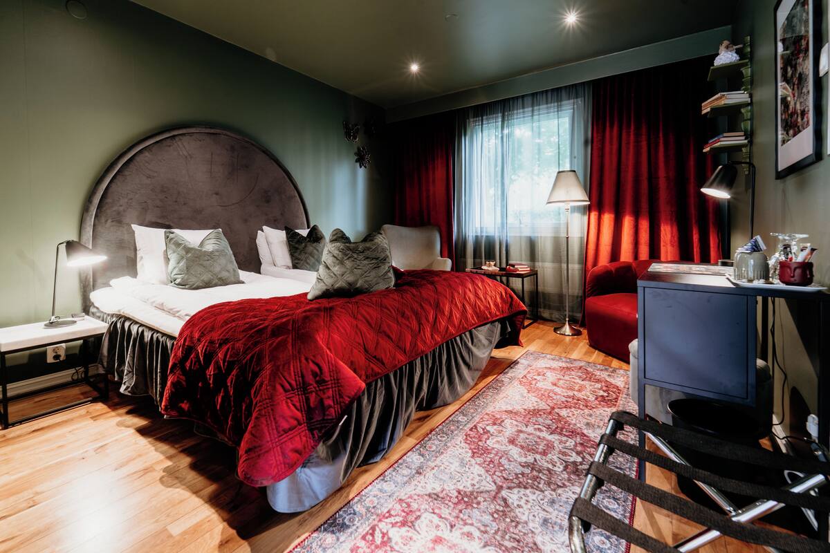 Ein modernes Schlafzimmer mit einem großen Bett, einem Schreibtisch und einem Sessel.