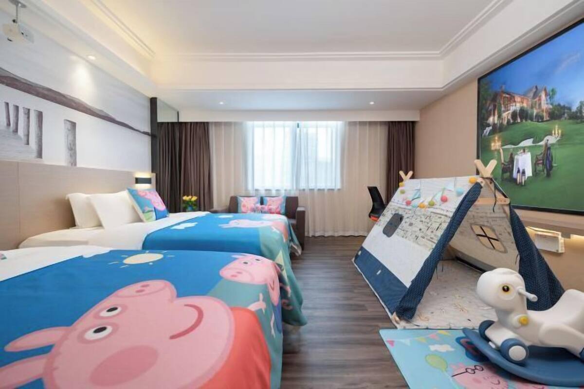 Hotellihuone, jossa on kaksi sänkyä, televisio, työpöytä ja näkymä golfkentälle.