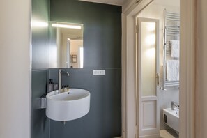 A bathroom with a white sink, a mirror, and a towel rack. - LAURANA, 6 – Spacious and bright apartment (Milano)