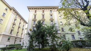 Un edificio de varios pisos con fachada simétrica, ventanas amplias y una entrada central.