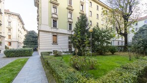 Un camino que lleva a un edificio con césped y setos.