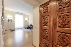 A spacious room with a wooden door, a sofa, and a rug. - SEMPIONE, 51 – Spacious and bright (Milano)