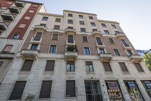 A multi-story building with a brick facade, multiple windows, and balconies.