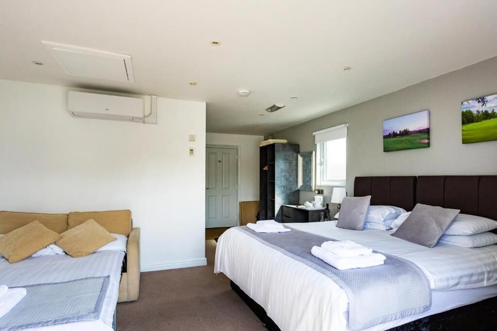 Une chambre d’hôtel avec un lit, un canapé, un bureau et un miroir.