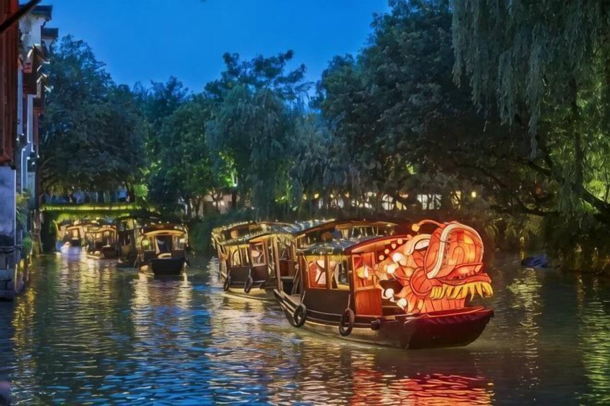 Escena fluvial amb barques il·luminades.