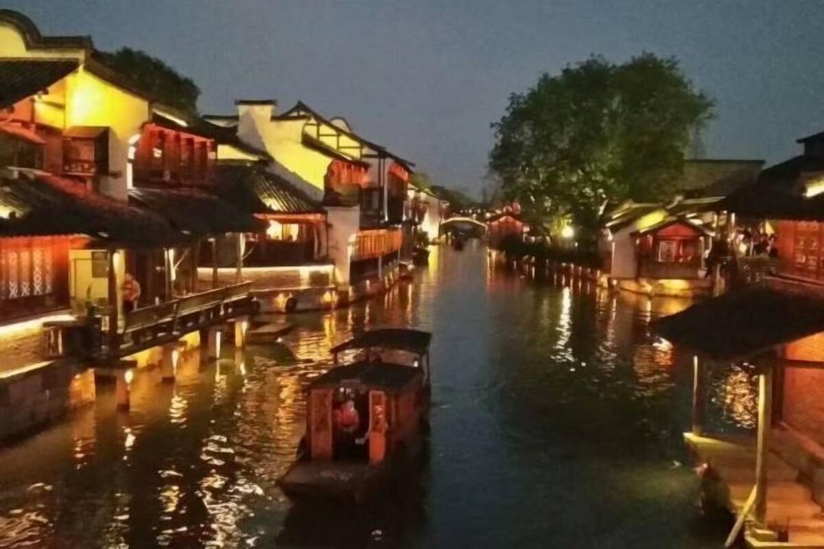 Un canal estret flanquejat per edificis tradicionals amb façanes il·luminades.