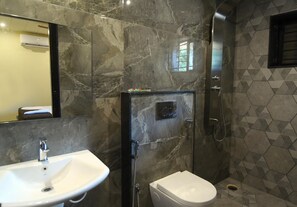 A modern bathroom with a marble sink, toilet, and shower.