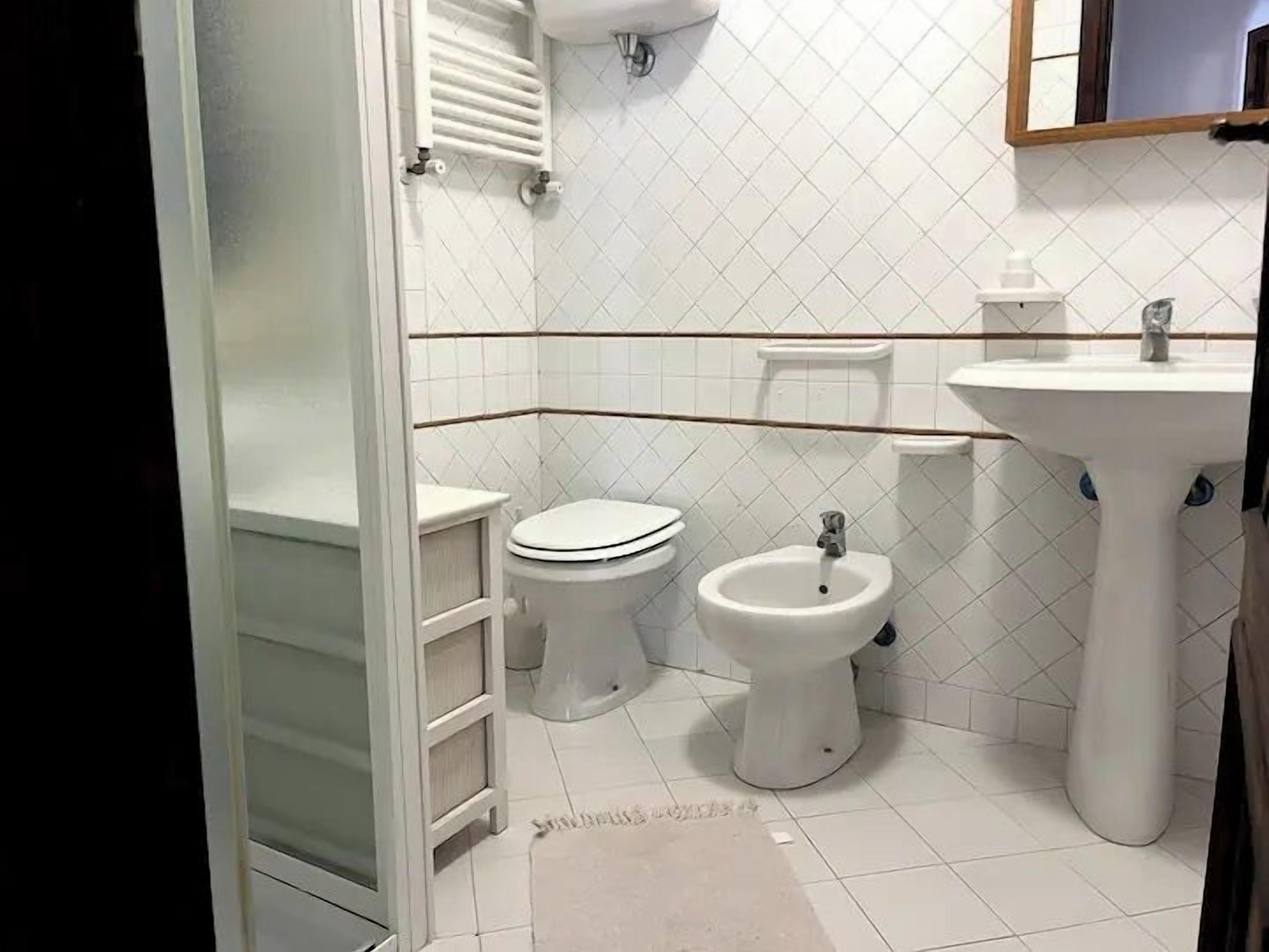 Un bagno con toilette, bidet e lavandino.