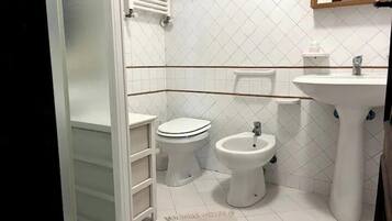 Un bagno con toilette, bidet e lavandino.