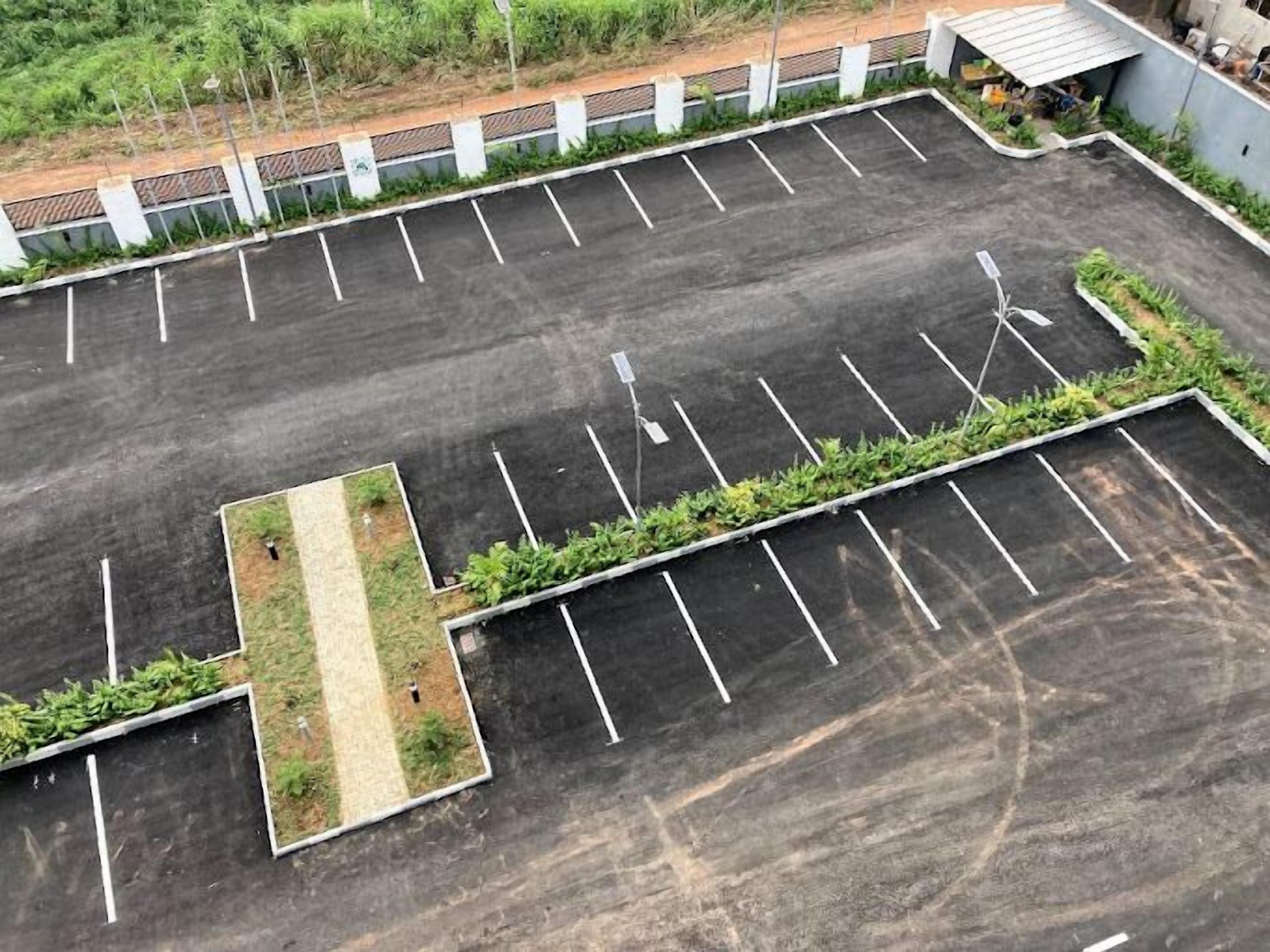 A parking lot with marked spaces and a central landscaped area.