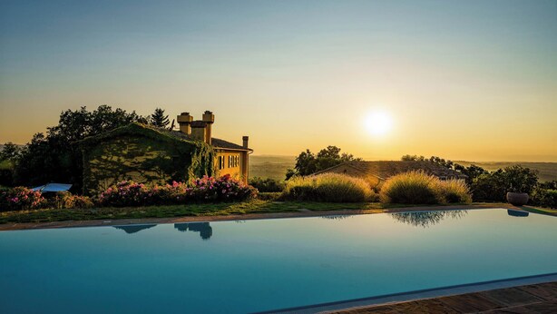 A swimming pool with a clear view of a house and surrounding greenery. - Villa Pietraia (Certaldo)