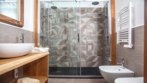 A modern bathroom with a large white sink, a glass-enclosed shower, and a bidet. - LOCANDA IL BUSCIOLOTTO (Santa Teresa di Gallura)