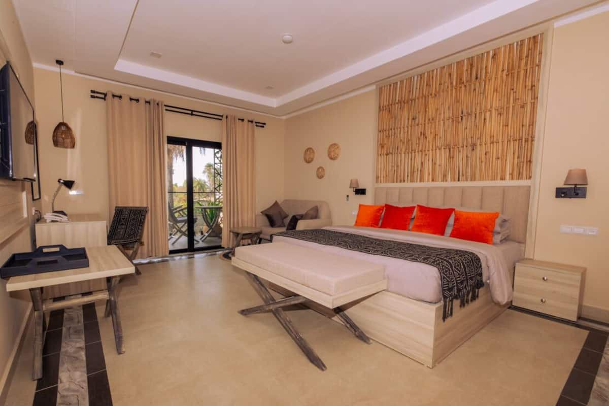 A bedroom with a bed, a desk, and a chair.