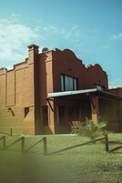 A building with a flat roof, a balcony, and a small garden area.