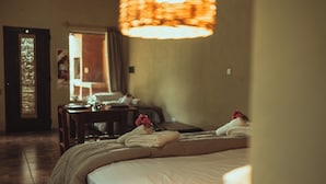 A hotel room with a bed, a desk, and a chair. - Hacienda Altomonte (San Rafael)
