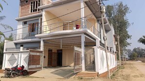 A two-story residential building with a covered entrance and a motorcycle parked outside. - VS Grand (Bara Banki)