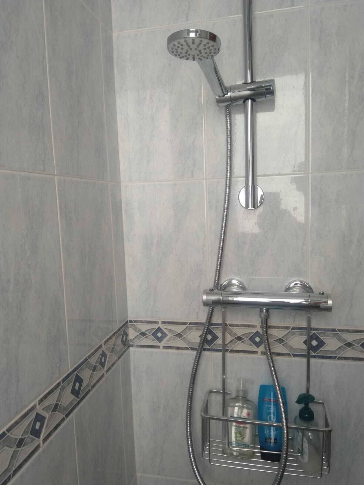 Een douche, handdoeken, zeep, toiletpapier