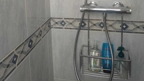 A shower with a handheld showerhead and a wall-mounted faucet. - Sunny beach apartment in Las Palmeres/Valencia (Sueca/Les Palmeres)