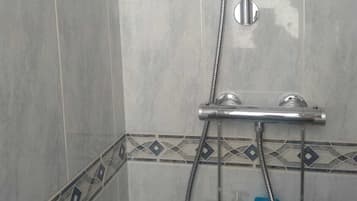 Een douche, handdoeken, zeep, toiletpapier