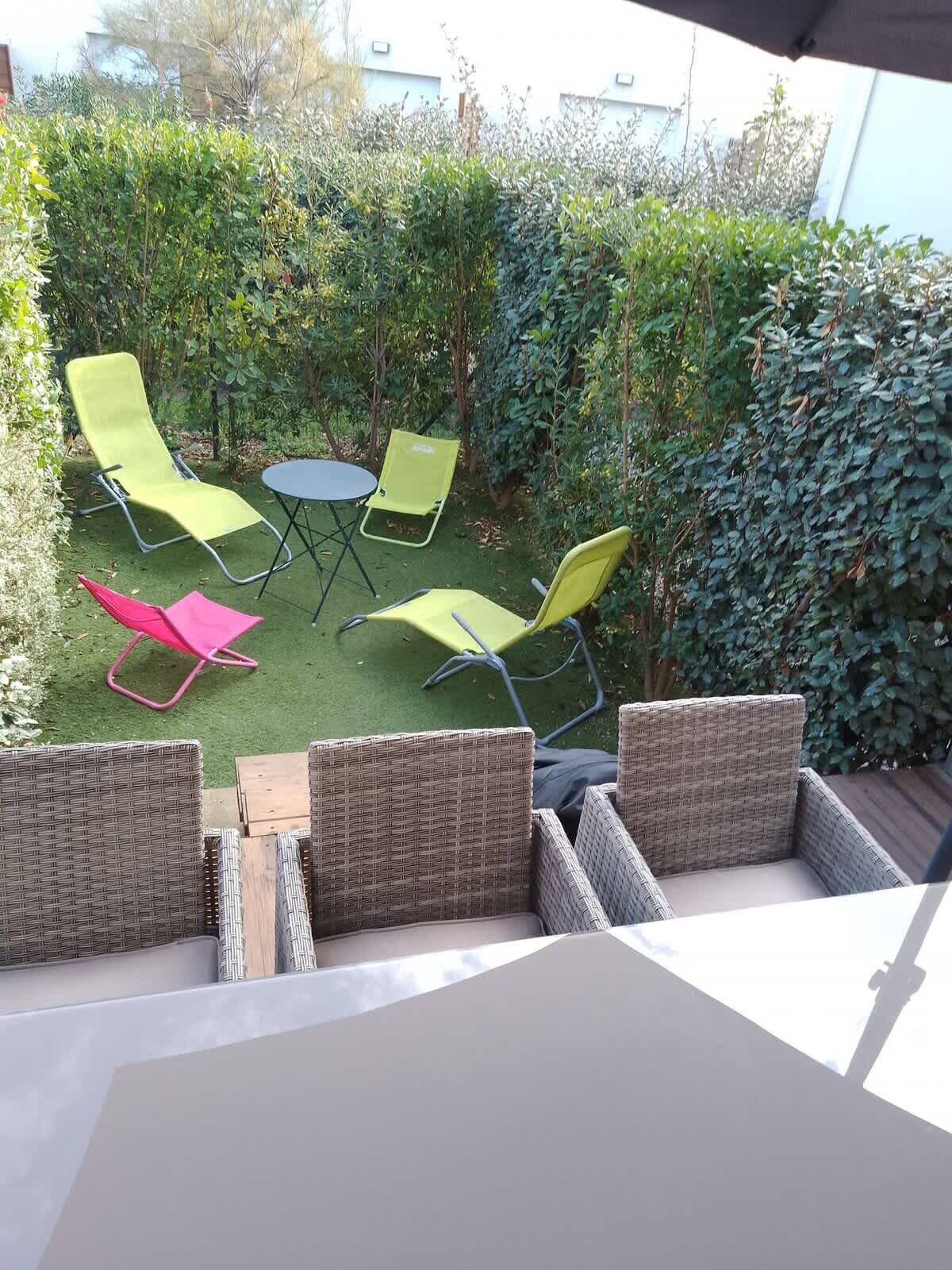 A patio with wicker furniture, a round table, and chairs.