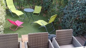 A patio with wicker furniture, a round table, and chairs.