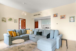 A modern living room with a sectional sofa, a coffee table, and artwork on the walls. - Rimal 3 - 208 1BD in Dubai (Dubai)