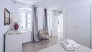 Ein modernes Schlafzimmer mit Bett, Stuhl, Schminktisch und Kleiderschrank.