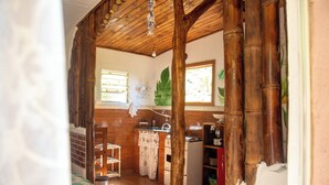 Una cocina rústica con vigas de madera, pared de ladrillo y ventana con vistas al verdor.