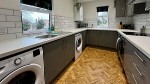 A modern kitchen with a built-in washing machine, a microwave, and a toaster. - 3 Bedroom Home in Wellington (Wellington)