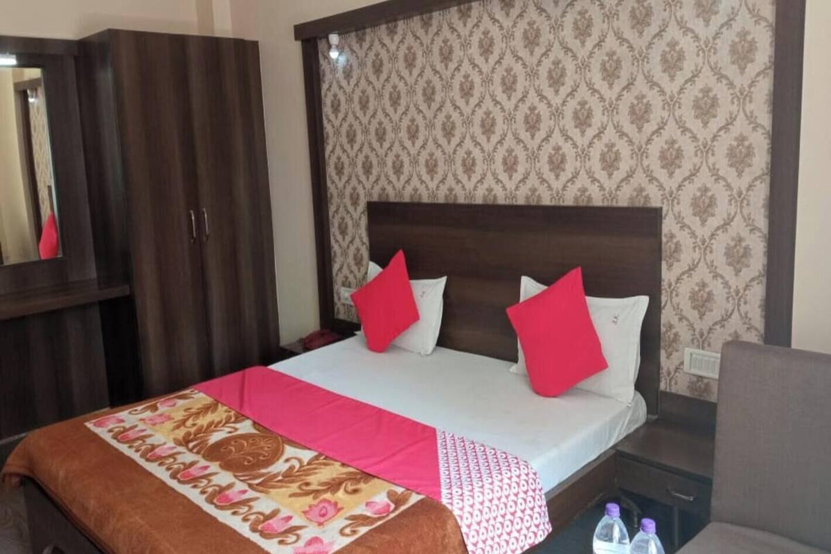 A hotel room with a bed, a wardrobe, and a nightstand.