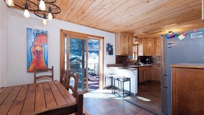 A wooden interior with a dining table, chairs, a kitchen area with wooden cabinets, a refrigerator, and a painting of a rooster. - Private home on 5 acres - 5 min. from downtown Durango - Hot Tub/Game Room (Durango)