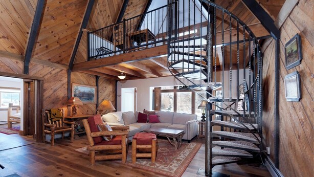 A spacious loft with a wooden interior, a spiral staircase, and a cozy seating area with a sofa and chairs. - Private home on 5 acres - 5 min. from downtown Durango - Hot Tub/Game Room (Durango)