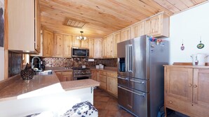 A kitchen with wooden cabinets, a stainless steel refrigerator, a microwave, and a stove. - Private home on 5 acres - 5 min. from downtown Durango - Hot Tub/Game Room (Durango)