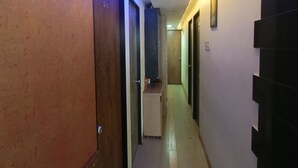A hallway with doors numbered 201 and 202, a small counter, and a staircase on the right. - HOTEL Sai Leela Residency (Mumbai)