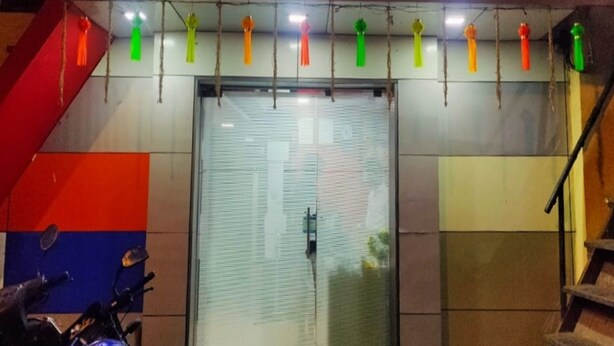 The exterior of Sai Leela Hotel with a brightly lit sign, a staircase, and a motorcycle parked in front. - HOTEL Sai Leela Residency (Mumbai)