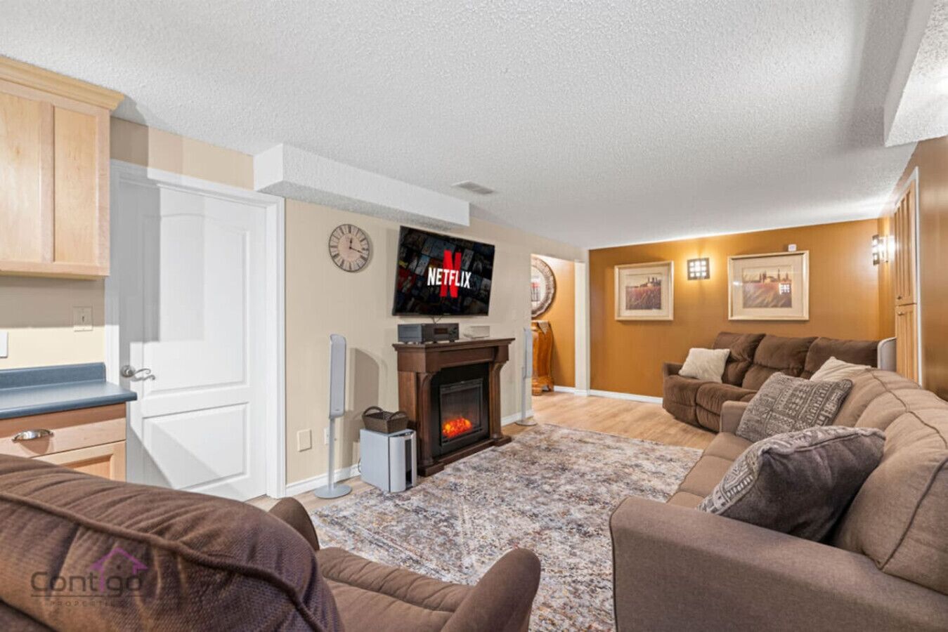 Ein Wohnzimmer mit Kamin, Wand-Fernseher und einer Couch.
