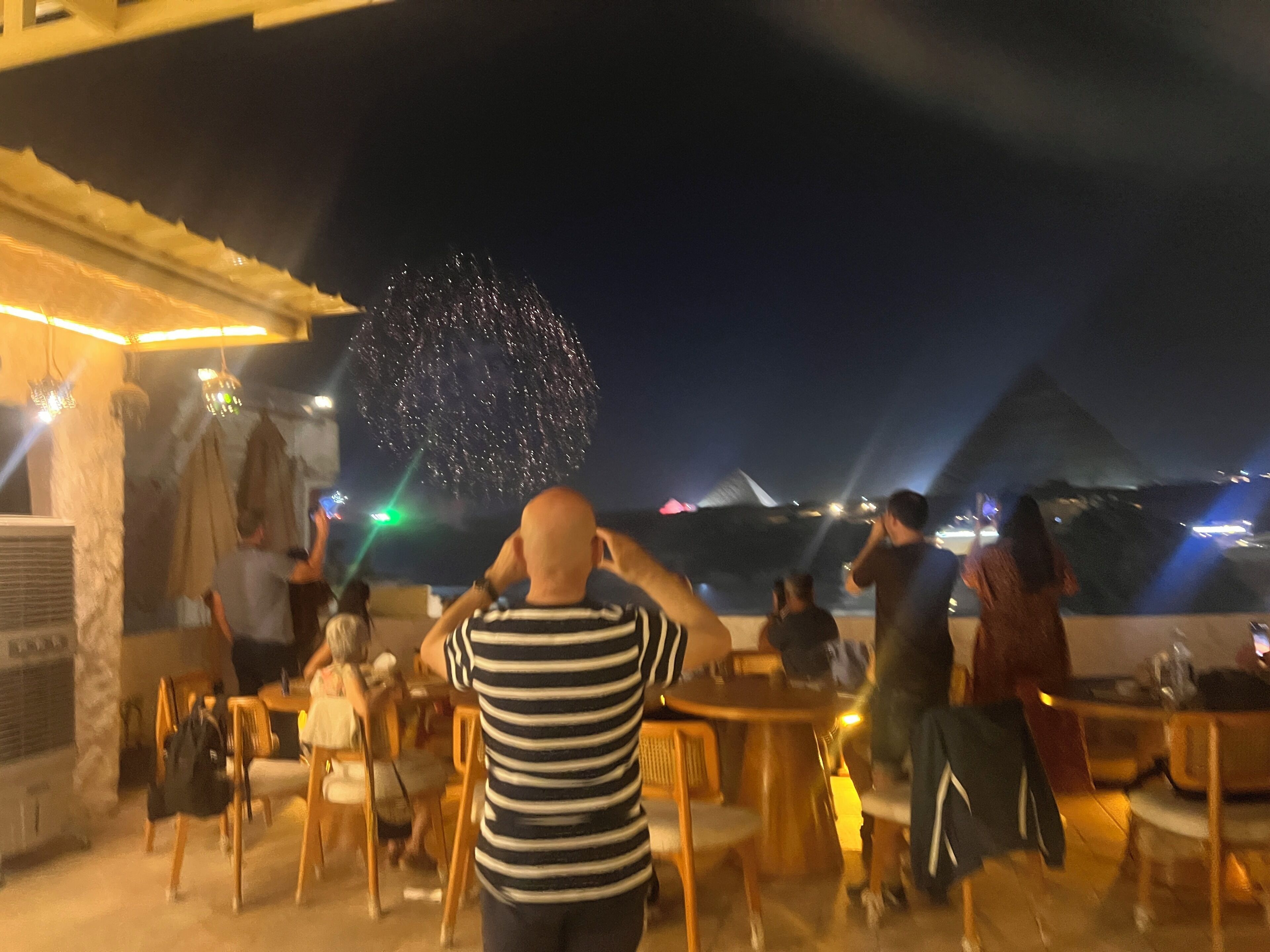 Un restaurante con terraza exterior con vistas a una pirámide.