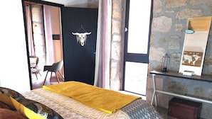 A room with a bed, a desk, a chair, and a wall-mounted mirror.