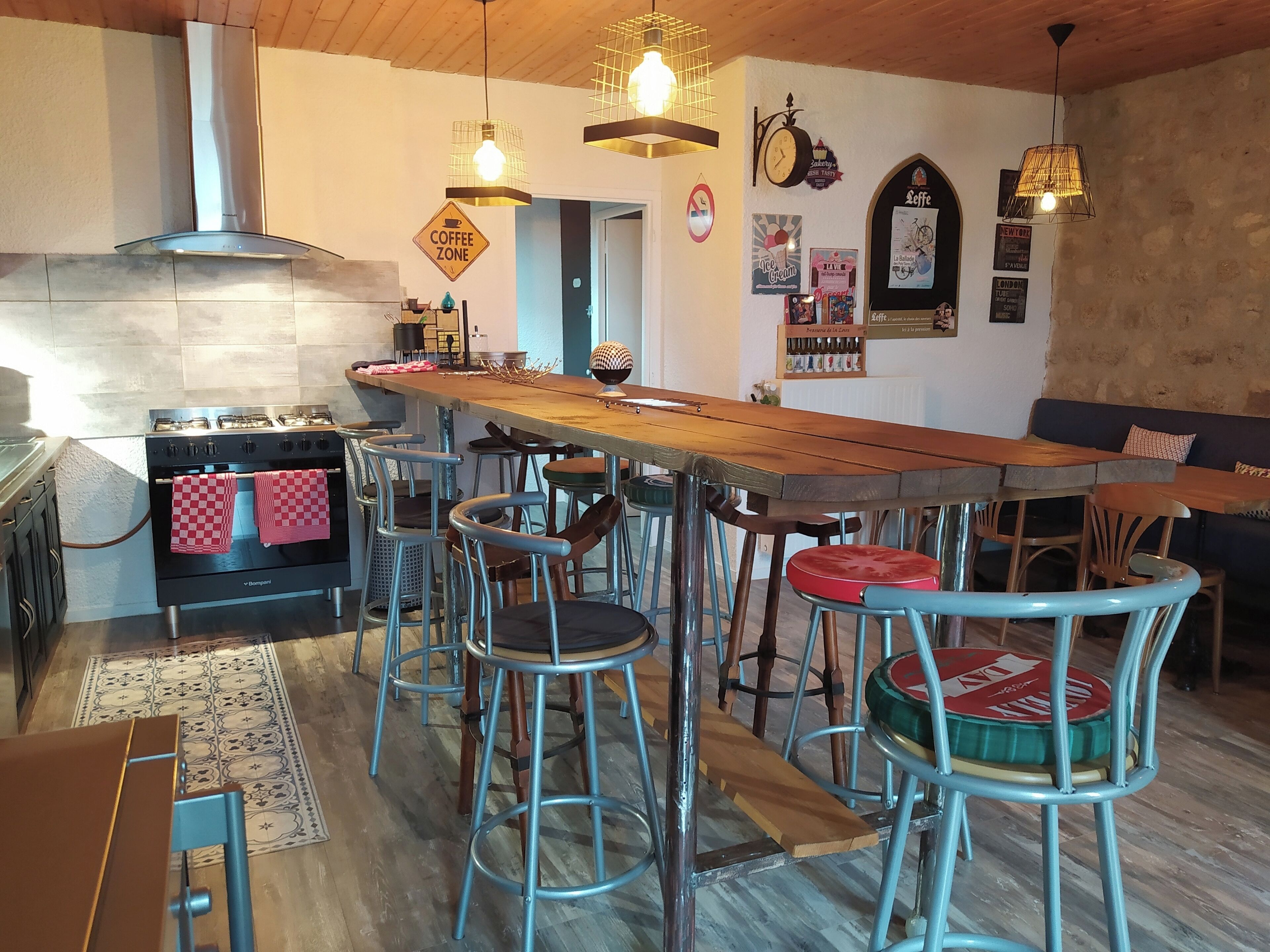 Una cocina acogedora con una isla central, taburetes de bar y una mesa de comedor.