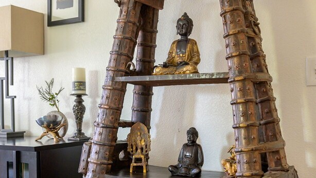 A wooden shelf with various statues and decorative items. - Resort style condo in Scottsdale (Scottsdale)