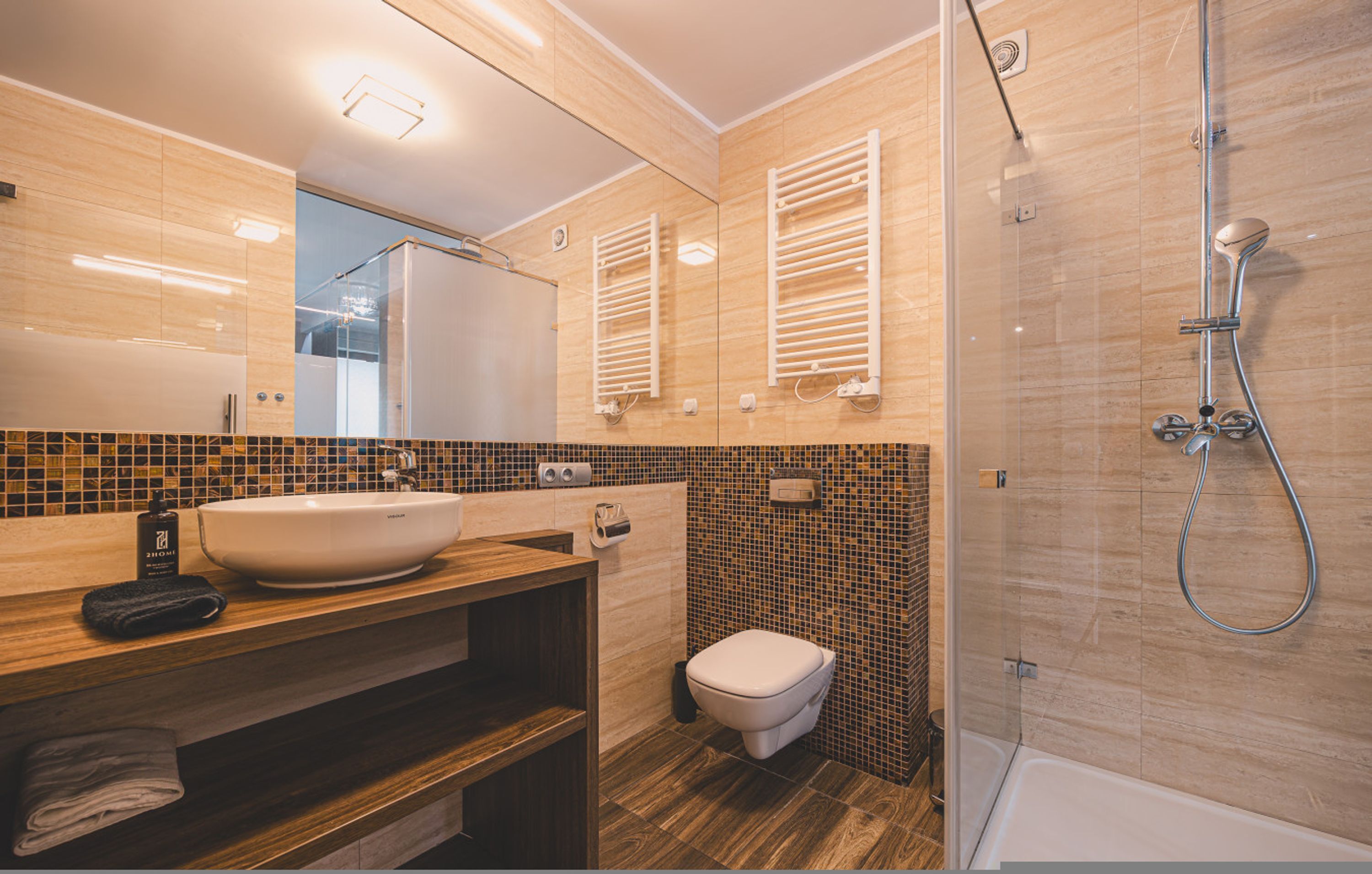 A modern bathroom with a large sink, a toilet, and a shower area.