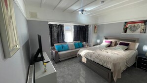 A bedroom with a bed, a sofa, a TV, and a desk. - Home Away From Away. Charming 2-bedroom apartment in wonderful Croydon with WiFi (Croydon)
