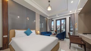 A hotel room with a large bed, a desk, a chair, and a balcony with a view. - Infinity HaNoi Hotel & Travel (Hanoi)