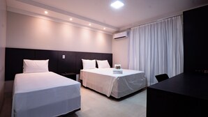 Een hotelkamer met twee bedden, een bureau en een televisie.