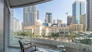 Un balcone con vista su un panorama urbano, che include edifici moderni e una moschea.