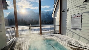An indoor hot tub with a view of mountains and a clear sky. - Whimsical Rocky Mt. Retreat by Banff National Park (Harvie Heights)