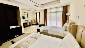 Una habitación de hotel con dos camas, un televisor, un escritorio y una silla.