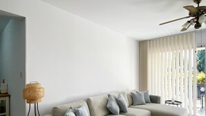 A modern living room with a beige sectional sofa, a wooden coffee table, and a floor lamp. - 70 PAP - Stay Anthea Gardens - Calm Living (Ayia Marinouda)