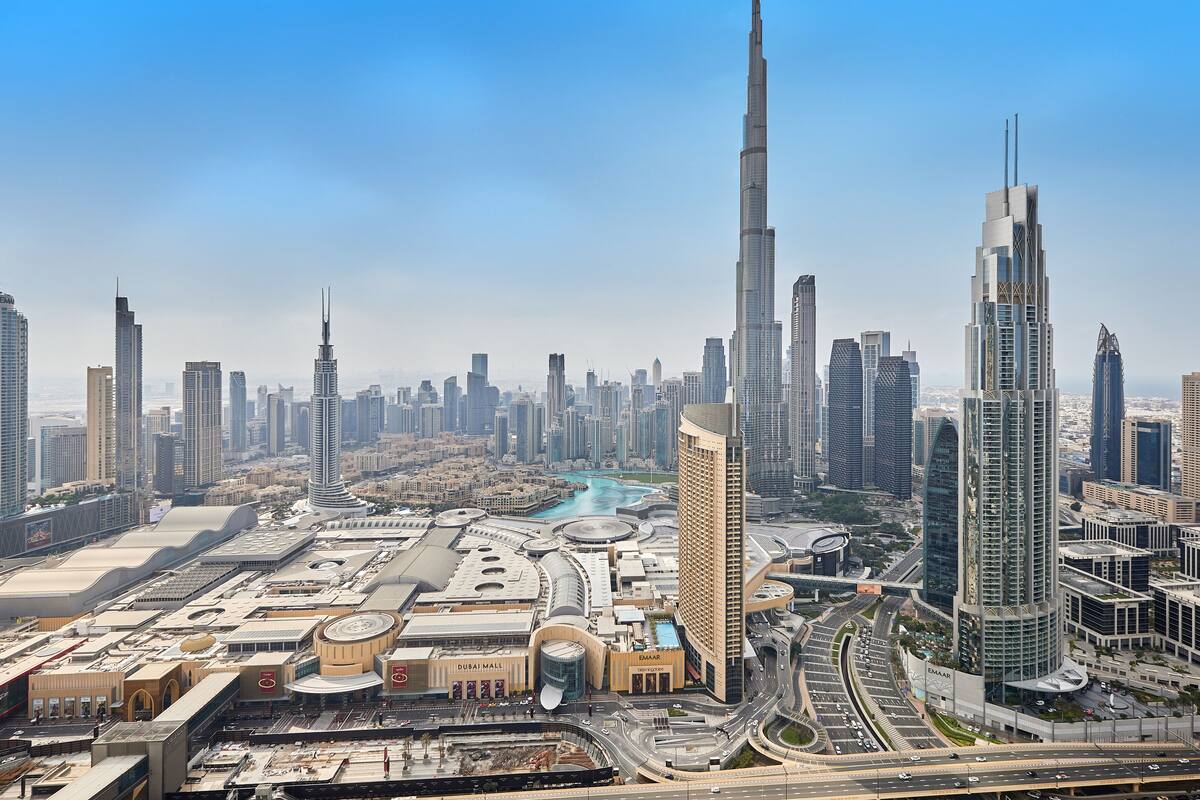 A high-rise building with a distinctive spire, surrounded by other tall skyscrapers in a densely built urban area.